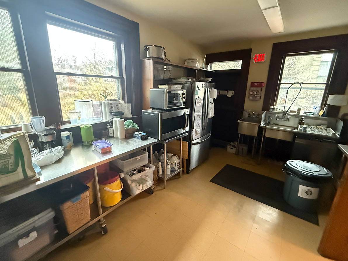 the dishwashing and handwashing stations, commercial dishwasher, refrigerator, and work area in the Parish Hall kitchen